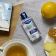 Cuticura Original Antibacterial quick dry hand gel 100ml on a table next to tissues and a lemon
