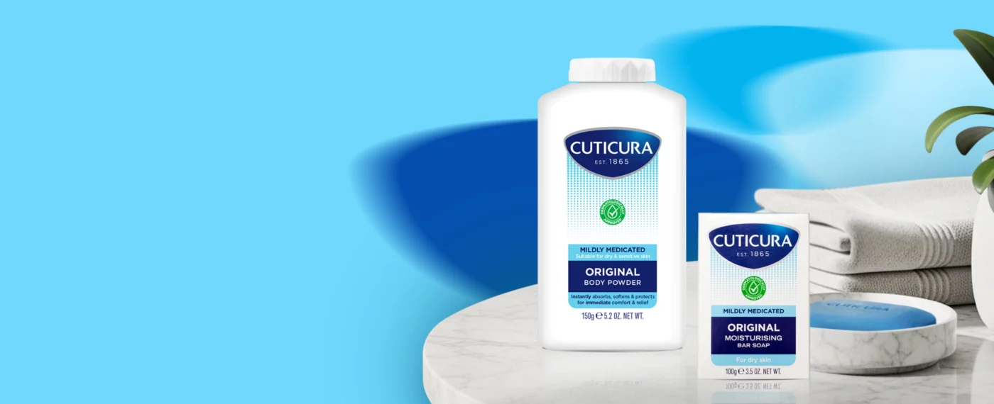 The Mildly Medicated Range included the Cuticura Bar Soap and Body Powder on a surface with a blue background.